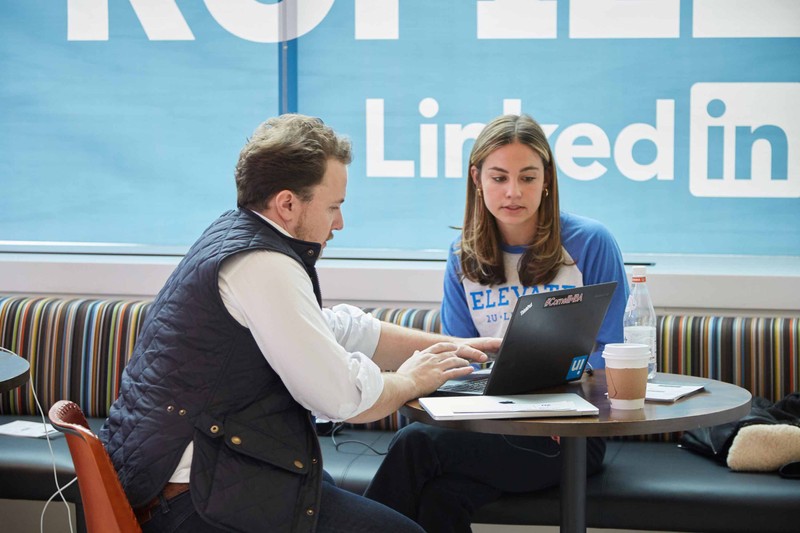 2U and LinkedIn colleagues work on a laptop in a break area